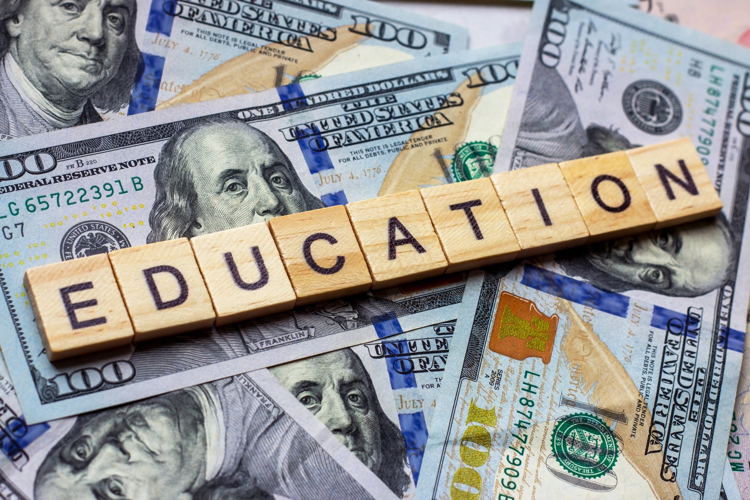 The word education on dollar usa background. College credits, graduation funds, tuition money concept