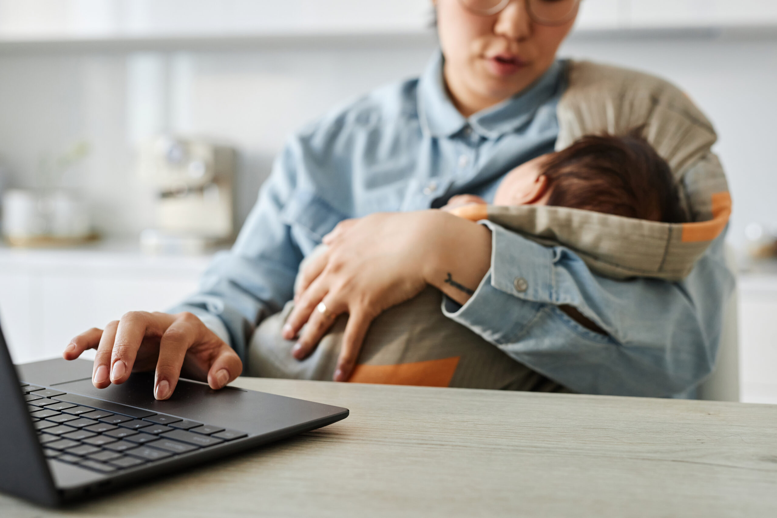 Mom with baby working online on laptop
